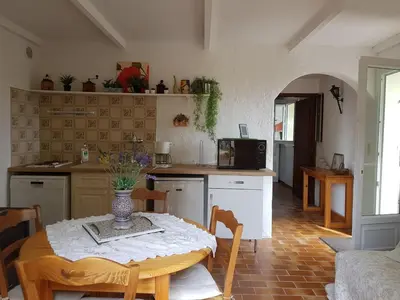 a kitchen with a table and a kitchen with a table and chairs at Nice Petite maison mitoyenne avec piscine in La Gaude
