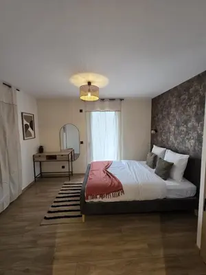 a bedroom with a bed and a table and a window at La costière in Nice