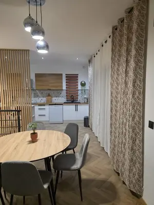 a dining room with a table and chairs and a kitchen at La costière in Nice