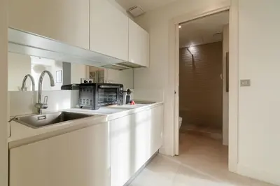 a white kitchen with a sink and a microwave at Maison Bianchi - Studio on avenue Jean Medecin in Nice