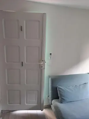 a white door in a room with a couch at Studio dans le vert in Nice