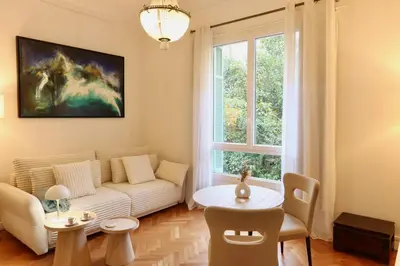 a living room with a couch and a table at Quiétude - Studio calme avec vue jardin en hyper centre de Nice in Nice