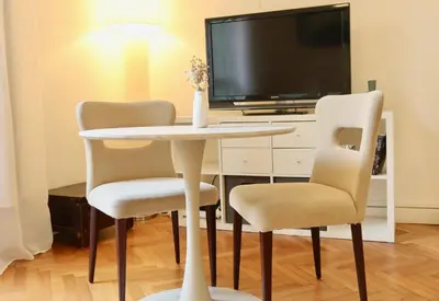 a table with two chairs and a tv in a room at Quiétude - Studio calme avec vue jardin en hyper centre de Nice in Nice