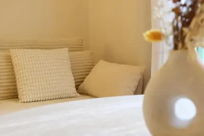 a bedroom with a bed with two pillows and a vase at Quiétude - Studio calme avec vue jardin en hyper centre de Nice in Nice