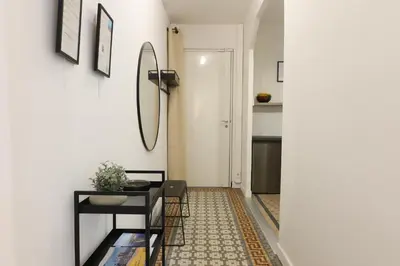 a hallway with a table and a mirror on a wall at Quiétude - Studio calme avec vue jardin en hyper centre de Nice in Nice