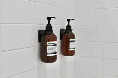 two bottles of soap on the wall of a bathroom at Quiétude - Studio calme avec vue jardin en hyper centre de Nice in Nice