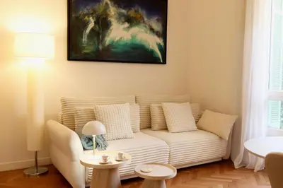 a living room with a couch and a painting on the wall at Quiétude - Studio calme avec vue jardin en hyper centre de Nice in Nice