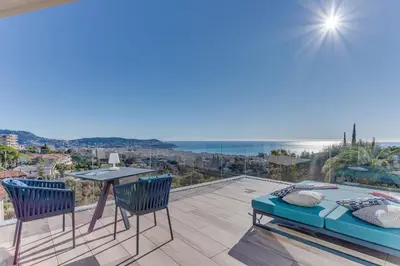 a balcony with a table and chairs and a view of the ocean at Villa Alba VI4498 by Riviera Holiday Homes in Nice