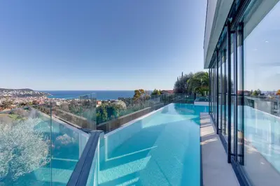 a swimming pool with a view of the ocean from a house at Villa Alba VI4498 by Riviera Holiday Homes in Nice