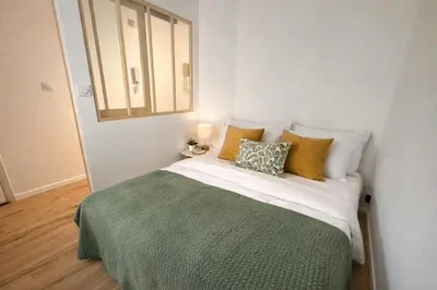 a bedroom with a bed with a green blanket and pillows at CALIF52 appartement avec terrasse à 3 min de la plage,1min tram in Nice