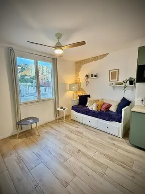 a bedroom with a bed with purple sheets on it at Charmant studio pour amoureux in Nice