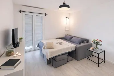 a small bedroom with a bed and a tv at Le Valrose - Calme & Terrasse in Nice
