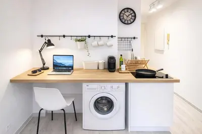 a kitchen with a desk with a laptop and a washing machine at Le Valrose - Calme & Terrasse in Nice