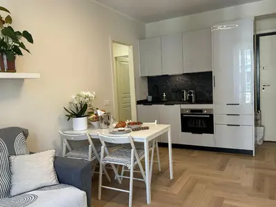 a kitchen with a white table and a table and chairs at Cozy Apartment in the heart of Nice in Nice