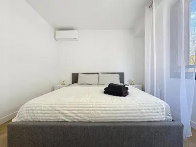 a black bag sitting on a bed in a bedroom at Appartement chic avec balcon Carré d Or Nice in Nice