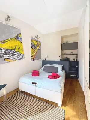 a bedroom with a bed and two paintings on the wall at Calm & Cozy Cocoon Place Masséna Downtown in Nice
