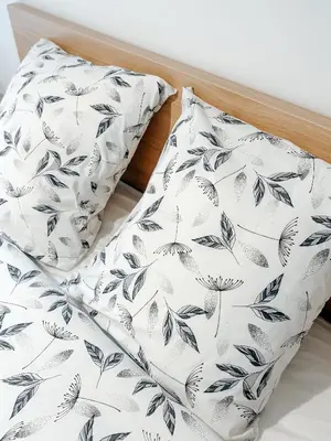 a bed with black and white sheets and a pillow at Aya - Renovated air-conditioned duplex with garden in Nice