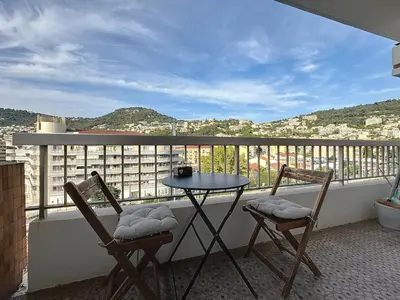 a balcony with two chairs and a table on a balcony at Évasion niçoise à 12 min du port Vue & confort in Nice