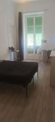 a bedroom with a bed and a desk and a window at plein centre Nice magnifique chambre double climatisée in Nice