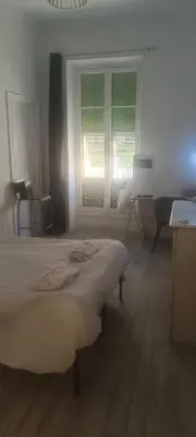 a bedroom with a bed and a window and a laptop at plein centre Nice magnifique chambre double climatisée in Nice
