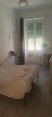 a bedroom with a bed and a desk and a window at plein centre Nice magnifique chambre double climatisée in Nice