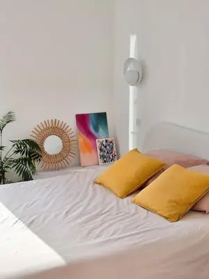 a white bed with two yellow pillows on it at Bright Artist's Apartment On Nice Hills in Nice