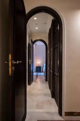 a hallway with an archway and a door with a room at Villa Belle Epoque, sea view, pool & hammam in Èze