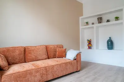 a couch sitting in a living room next to a wall at Elegant apartment - Haut Musiciens in Nice