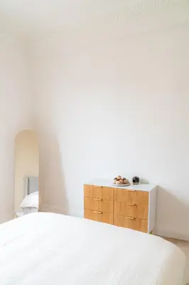 a bedroom with a white bed and a wooden cabinet at Elegant apartment - Haut Musiciens in Nice