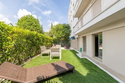 a backyard with a table and chairs on the grass at Cagnes sur mer, 1 bedroom with Garden-Air conditioning-Wifi in Cagnes-sur-Mer