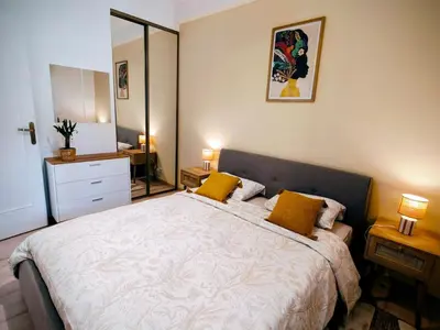 a bedroom with a large bed with two yellow pillows at Modern Gem 200m from Beaches with Balcony, AC and Tram in Nice