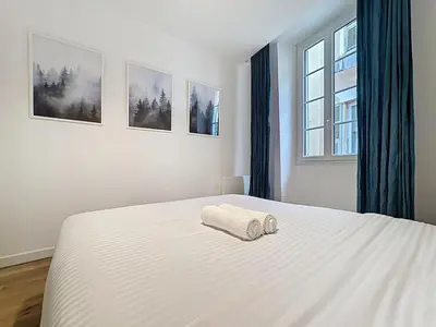 a bedroom with a white bed with a towel on it at Séjour idéal au cœur du Vieux-Nice in Nice