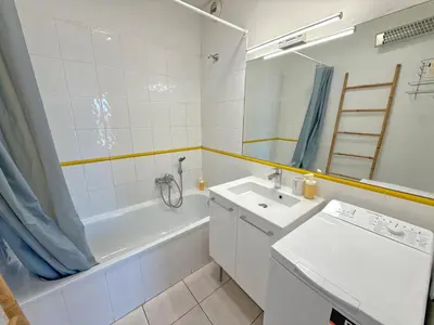 a bathroom with a sink and a tub and a toilet and a mirror at 4-person apartment - Air conditioning and Pool in Nice