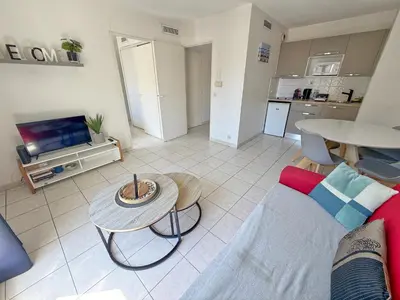 a living room with a couch and a table at 4-person apartment - Air conditioning and Pool in Nice