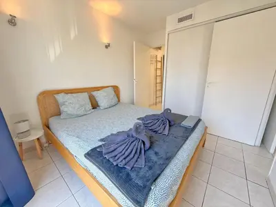 a bedroom with a bed with towels on it at 4-person apartment - Air conditioning and Pool in Nice