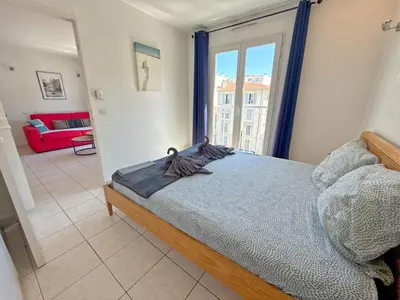 a bedroom with a bed and a large window at 4-person apartment - Air conditioning and Pool in Nice