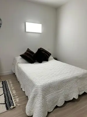 a white bed with black pillows in a bedroom at Studio - Nice Palais des Expositions in Nice
