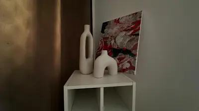 two white vases sitting on a table next to a painting at Appartement elegant a Nice in Nice