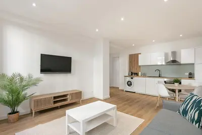 a living room with a couch and a table at Élégant 2 pièces Niçois - Carré d'Or - Centre Ville - Mer à 2 min in Nice