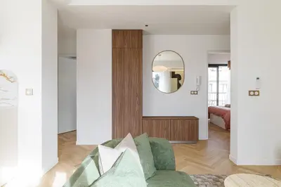 a living room with a green couch and a mirror at Appartement Mamabaldi in Nice