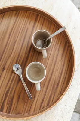 a wooden plate with a cup of coffee and a spoon at Appartement Mamabaldi in Nice