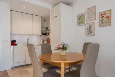 a kitchen and dining room with a wooden table and chairs at flora in Beaulieu-sur-Mer