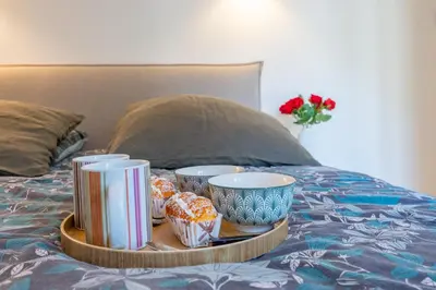 a tray with cups and snacks on a bed at flora in Beaulieu-sur-Mer