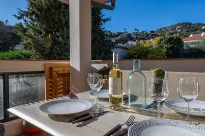 a table with a bottle of wine and glasses at flora in Beaulieu-sur-Mer
