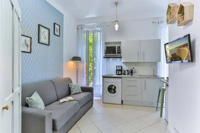 a living room with a couch and a kitchen at GROSSO 1 MD - New 3 minutes from the Sea in Nice