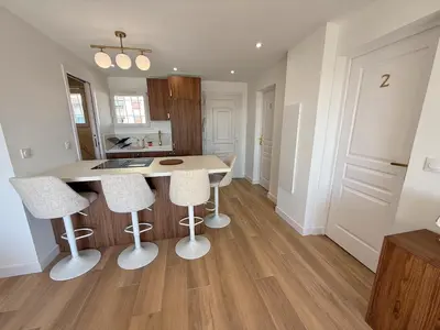 a kitchen with a table and four stools at Nice Ouest Chambres Privees Modernes TV Wifi Bureau in Nice