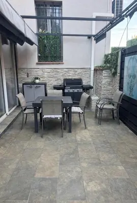 a patio with tables and chairs and a building at T4 Front de mer Piscine interieure privee Clim in Cagnes-sur-Mer