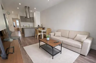 a living room with a couch and a table at RAIMBALDI Urban Gare - Spacieux T3 climatisé au cœur du centre-ville in Nice