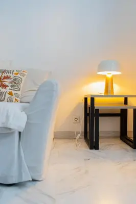 a living room with a couch and a table with a lamp at Rue Michelet in Nice