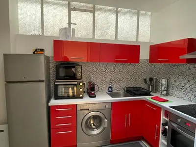 a kitchen with red cabinets and a washing machine at One-Bedroom Apartment near Promenade des Anglais in Nice